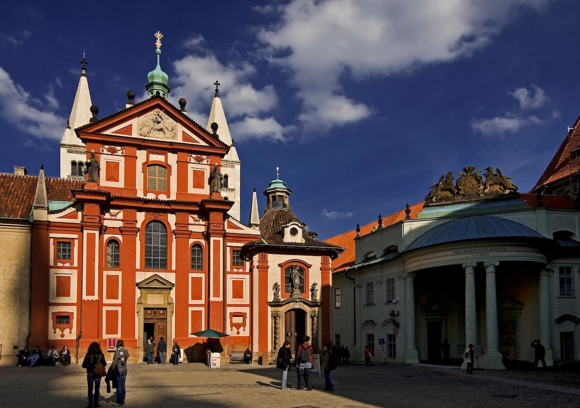 A magnificent Baroque church characterized by its bright orange façade, adorned with statues.