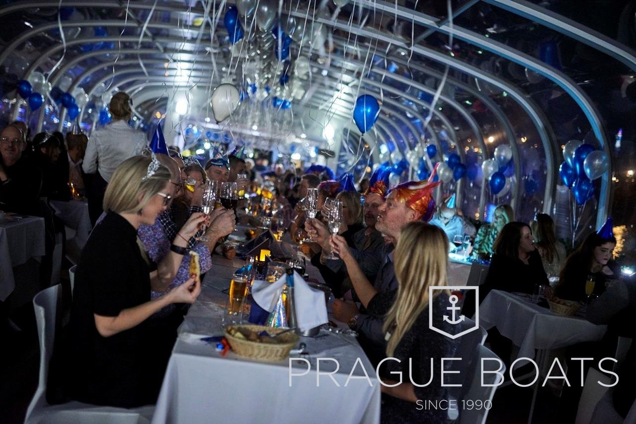 People sitting at a table, chatting and eating on a decorated boat